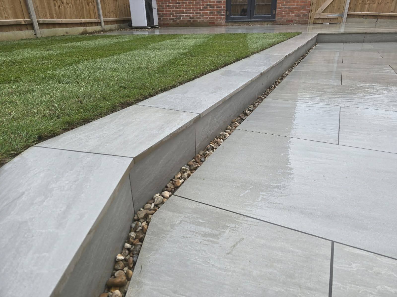 Block paving driveway with timber double gates and mature hedgerow