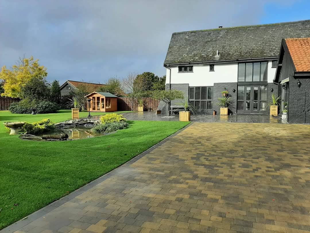 Block paving driveway with lawn, pond and summer house beside converted barn