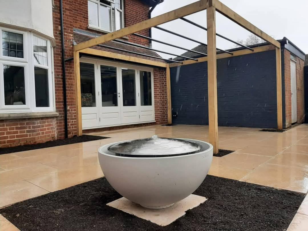 Sandstone patio with bowl water feature and timber pergola